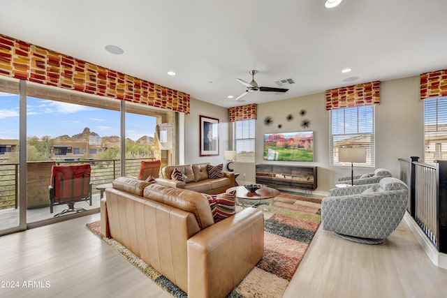 living room with light wood-type flooring and ceiling fan