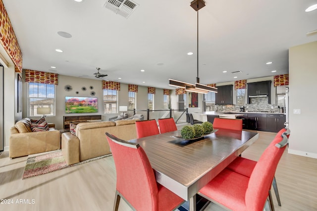 dining room with ceiling fan and light hardwood / wood-style floors