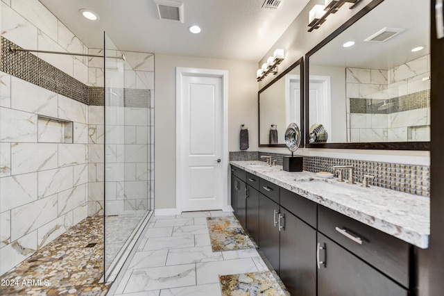 bathroom with tiled shower, backsplash, and vanity