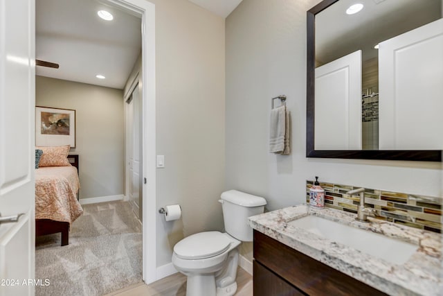 bathroom with toilet, backsplash, and vanity