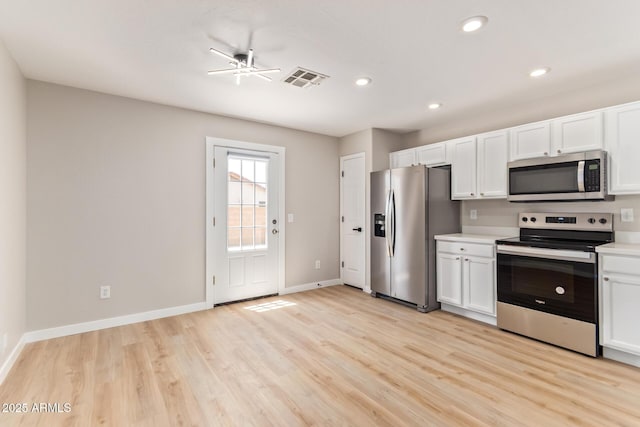 kitchen featuring white cabinets, light wood finished floors, light countertops, stainless steel appliances, and baseboards