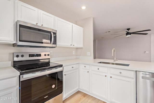 kitchen featuring ceiling fan, appliances with stainless steel finishes, a sink, light countertops, and white cabinetry