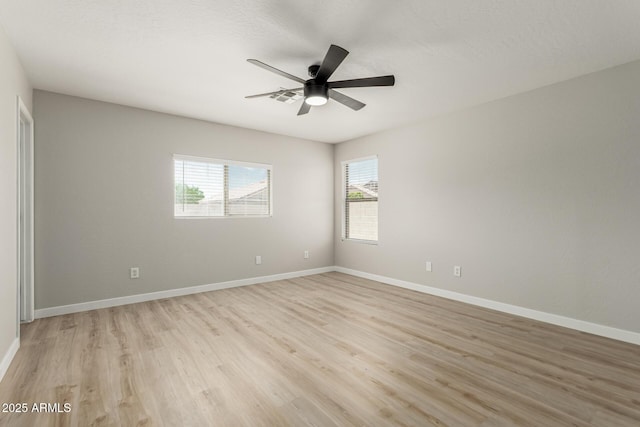 spare room with baseboards, ceiling fan, and light wood-style flooring