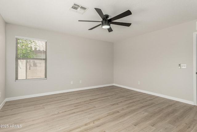 empty room featuring baseboards, visible vents, ceiling fan, and light wood finished floors