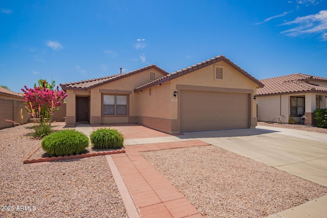 view of front of home featuring a garage, driveway, a tile roof, and stucco siding