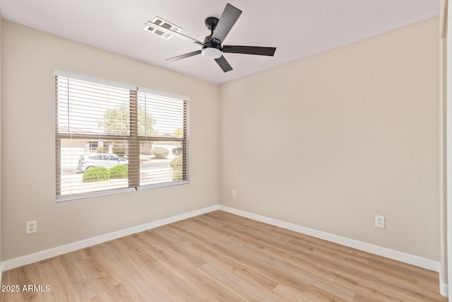 empty room featuring baseboards, a ceiling fan, light wood finished floors, and visible vents