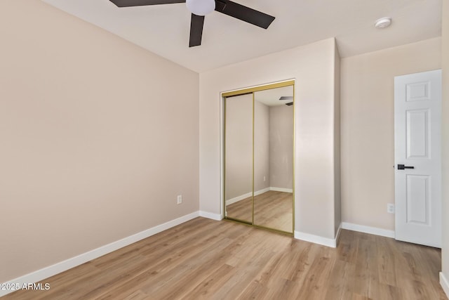 unfurnished bedroom with a closet, a ceiling fan, baseboards, and light wood-type flooring