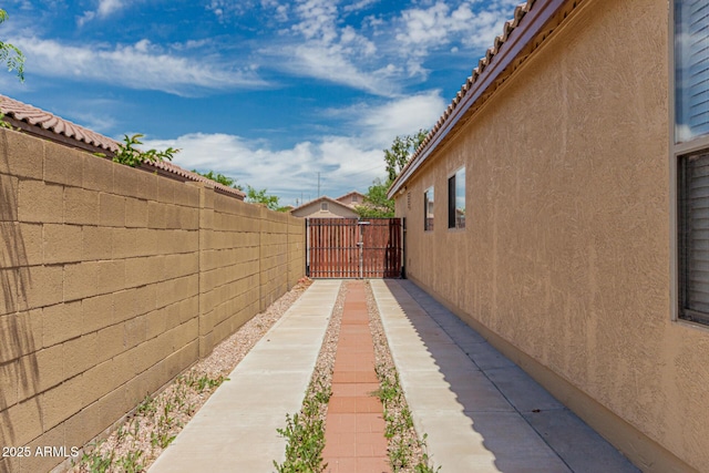 view of home's exterior with fence, a gate, and stucco siding