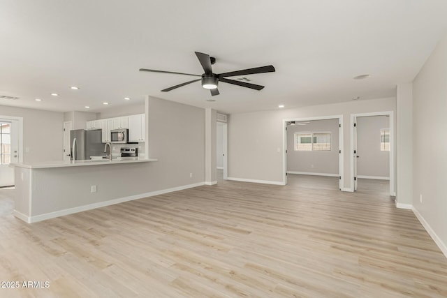unfurnished living room featuring light wood-style floors, baseboards, a ceiling fan, and recessed lighting