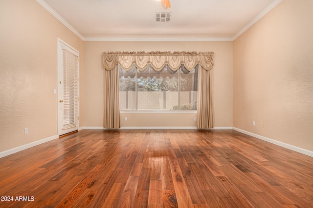 spare room featuring wood-type flooring and ornamental molding