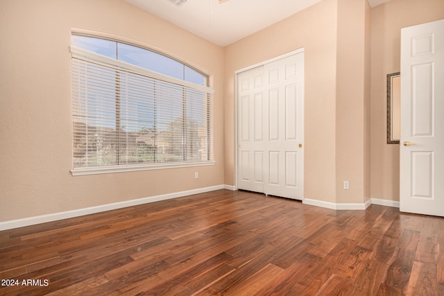 unfurnished bedroom featuring a closet and dark hardwood / wood-style flooring