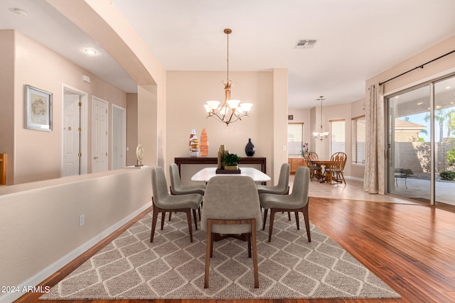 dining space featuring wood-type flooring and a chandelier