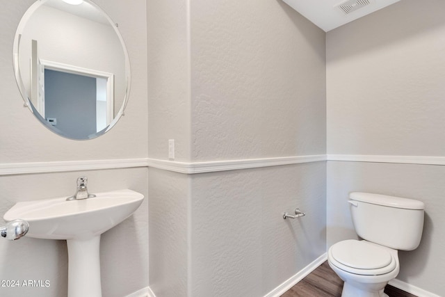 bathroom featuring toilet and wood-type flooring