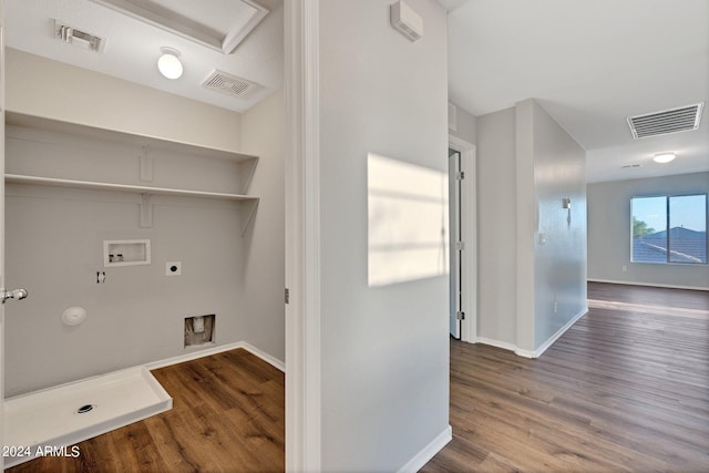 washroom with hardwood / wood-style flooring, washer hookup, hookup for an electric dryer, and gas dryer hookup