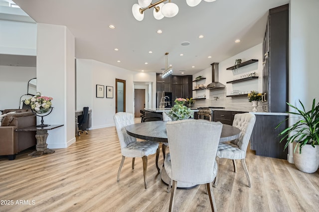dining area with light wood-type flooring, baseboards, recessed lighting, and a chandelier