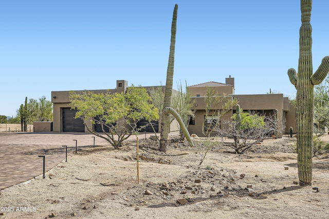 pueblo-style home with stucco siding and a garage