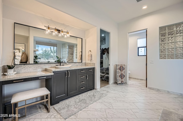 full bathroom featuring plenty of natural light, baseboards, marble finish floor, and vanity