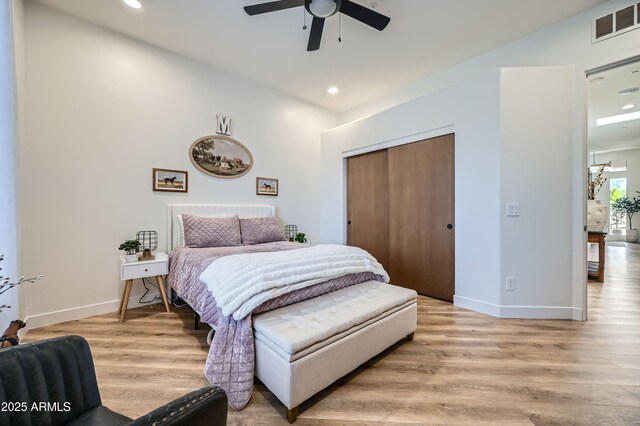 bedroom with a closet, visible vents, light wood finished floors, and baseboards