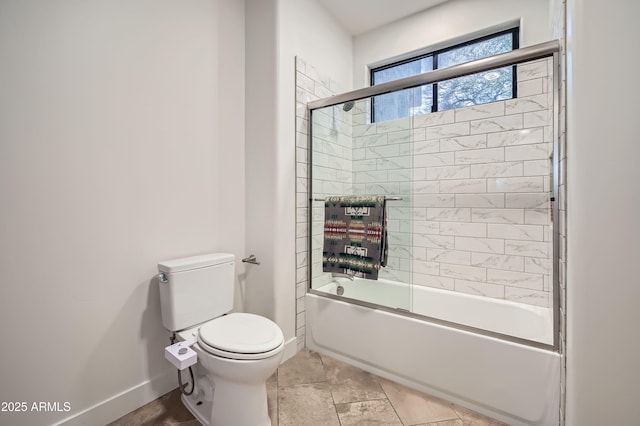 bathroom with baseboards, bath / shower combo with glass door, and toilet