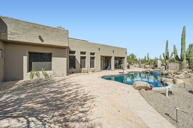 view of pool featuring fence, a patio area, and a pool with connected hot tub