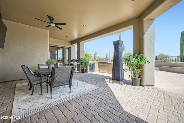 view of patio / terrace featuring outdoor dining space, fence, exterior kitchen, area for grilling, and ceiling fan