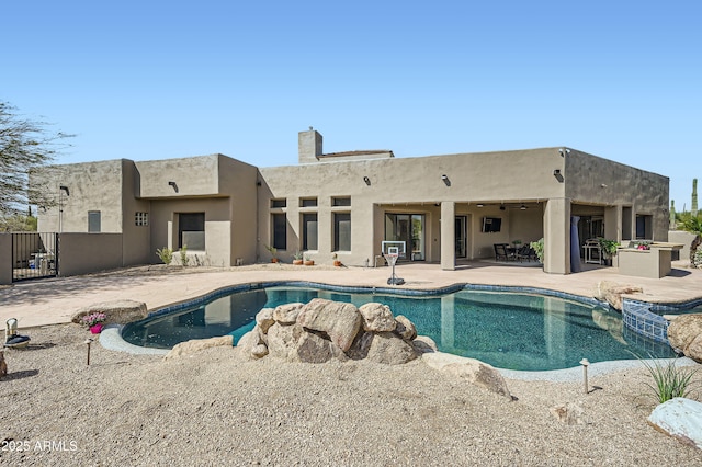 view of pool with fence, a pool with connected hot tub, and a patio