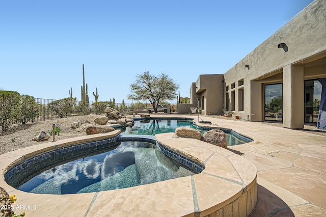 view of swimming pool featuring a patio area, a fenced backyard, a fenced in pool, and an in ground hot tub