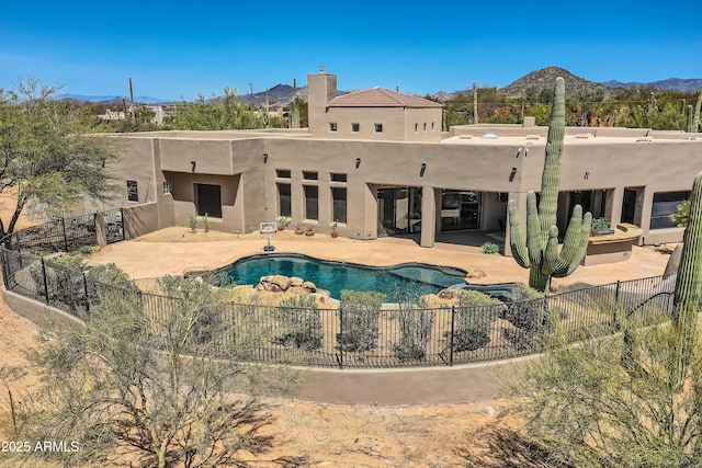 rear view of house featuring a fenced in pool, a chimney, fence, a patio, and a mountain view