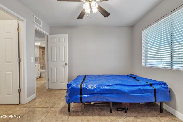 tiled bedroom featuring ceiling fan