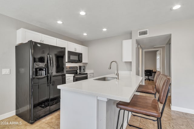 kitchen featuring kitchen peninsula, light tile patterned floors, white cabinetry, black appliances, and sink