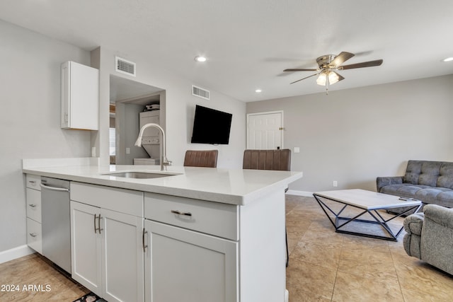 kitchen with kitchen peninsula, ceiling fan, white cabinetry, dishwasher, and sink