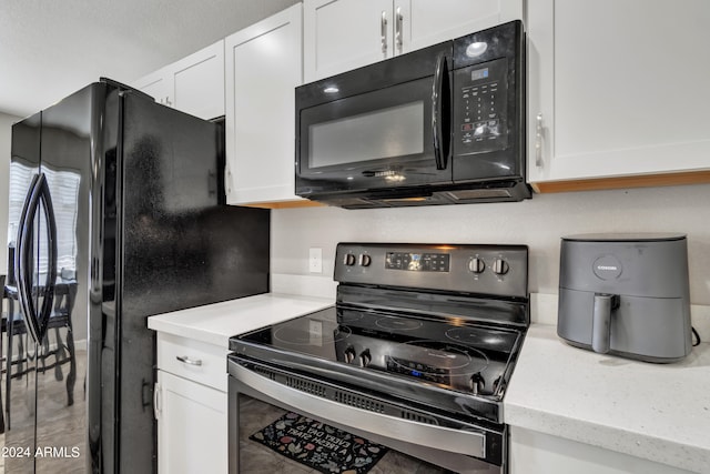 kitchen with black appliances and white cabinets