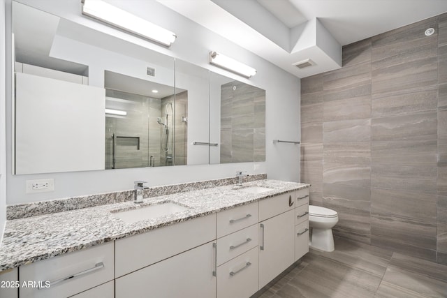 7180 E Kierland Blvd Unit 507, Scottsdale, AZ 85254 - full bathroom with double vanity, a stall shower, and tile walls