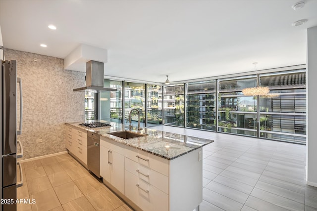 7180 E Kierland Blvd Unit 507, Scottsdale, AZ 85254 - kitchen with range hood, appliances with stainless steel finishes, a peninsula, light stone counters, and expansive windows