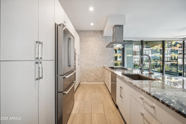 7180 E Kierland Blvd Unit 507, Scottsdale, AZ 85254 - kitchen featuring appliances with stainless steel finishes, dark stone countertops, island exhaust hood, white cabinets, and recessed lighting