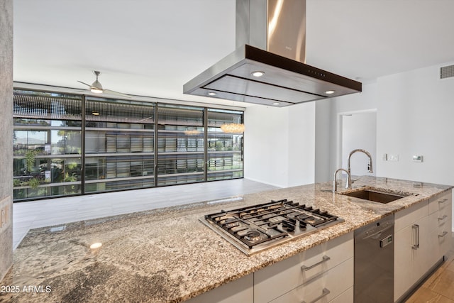 7180 E Kierland Blvd Unit 507, Scottsdale, AZ 85254 - kitchen with island range hood, dishwasher, stainless steel gas cooktop, a ceiling fan, and light stone counters