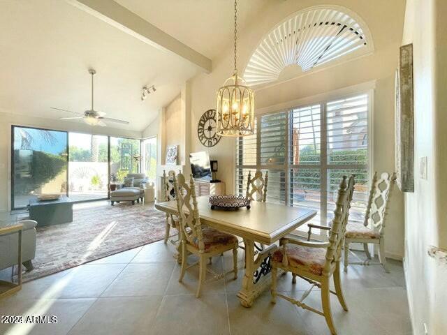 10063 E Cinnabar Ave, Scottsdale, AZ 85258 - dining room featuring ceiling fan with notable chandelier, light tile patterned floors, lofted ceiling, and a wealth of natural light
