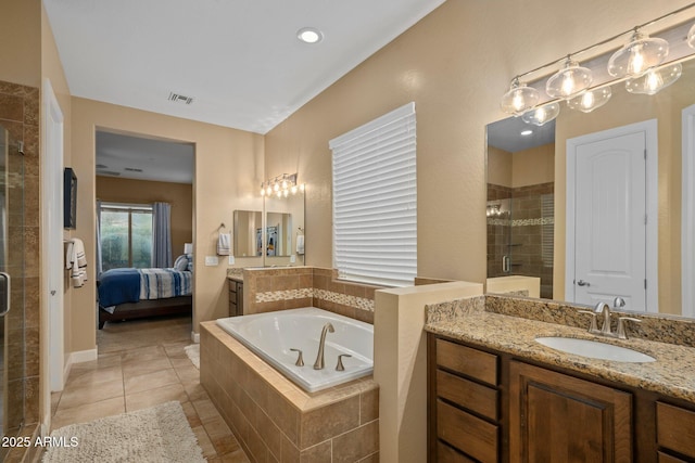 ensuite bathroom featuring a shower stall, a garden tub, vanity, and tile patterned floors