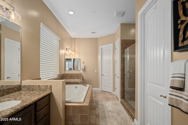 bathroom featuring a garden tub, a shower stall, vanity, and tile patterned floors