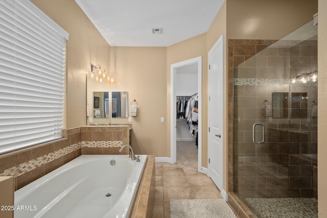 bathroom featuring a shower stall, a bath, a walk in closet, and tile patterned floors