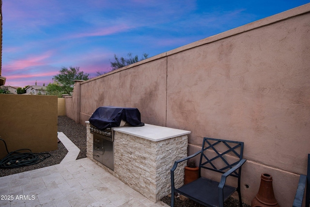 view of patio featuring an outdoor kitchen, grilling area, and fence