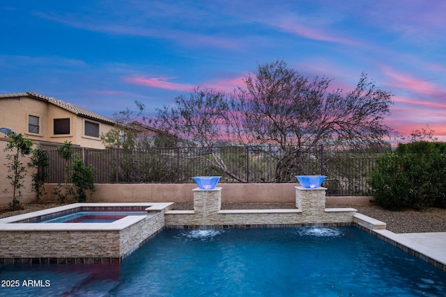 pool at dusk featuring an in-ground hot tub and fence