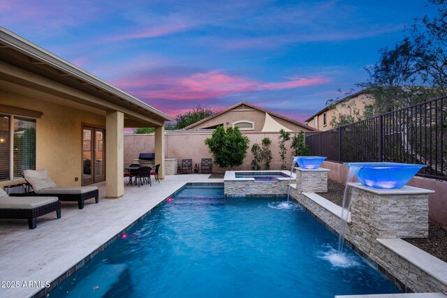 view of swimming pool with a patio, a fenced backyard, and a pool with connected hot tub
