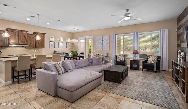 living area with plenty of natural light, ceiling fan, recessed lighting, light tile patterned flooring, and baseboards