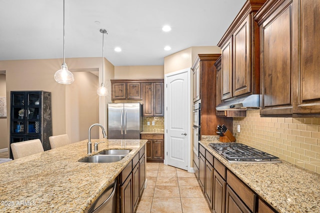 kitchen featuring a sink, appliances with stainless steel finishes, under cabinet range hood, light stone counters, and recessed lighting