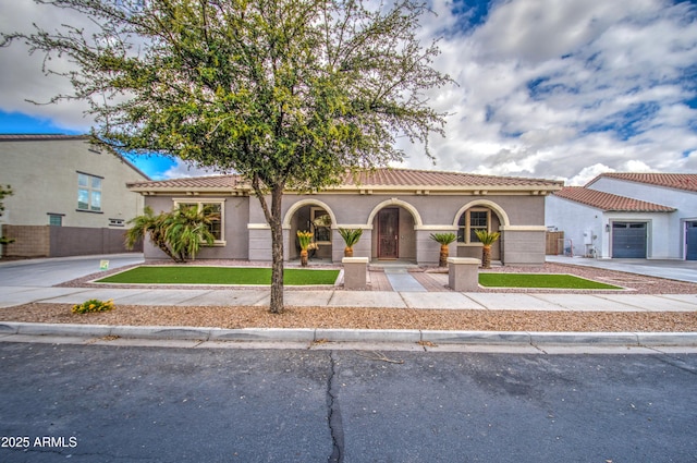 view of front of house featuring stucco siding, a tiled roof, driveway, and a front yard