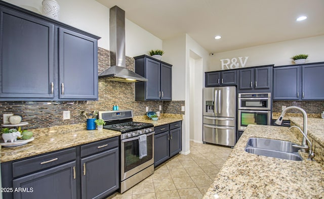 kitchen with backsplash, wall chimney exhaust hood, appliances with stainless steel finishes, and a sink