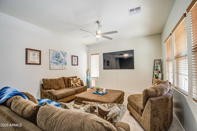 living room featuring visible vents, baseboards, a ceiling fan, and carpet floors