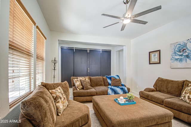 carpeted living area featuring baseboards and a ceiling fan