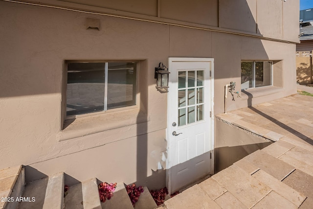 view of exterior entry with a patio area